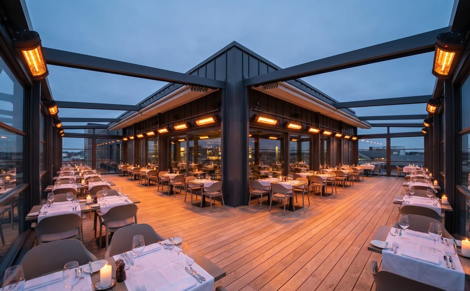 Cirka 30 PRO V70R infravärmare monterade i rader på en takterrass-restaurang, alla aktiva samtidigt med Auto-Restart för central strömstyrning